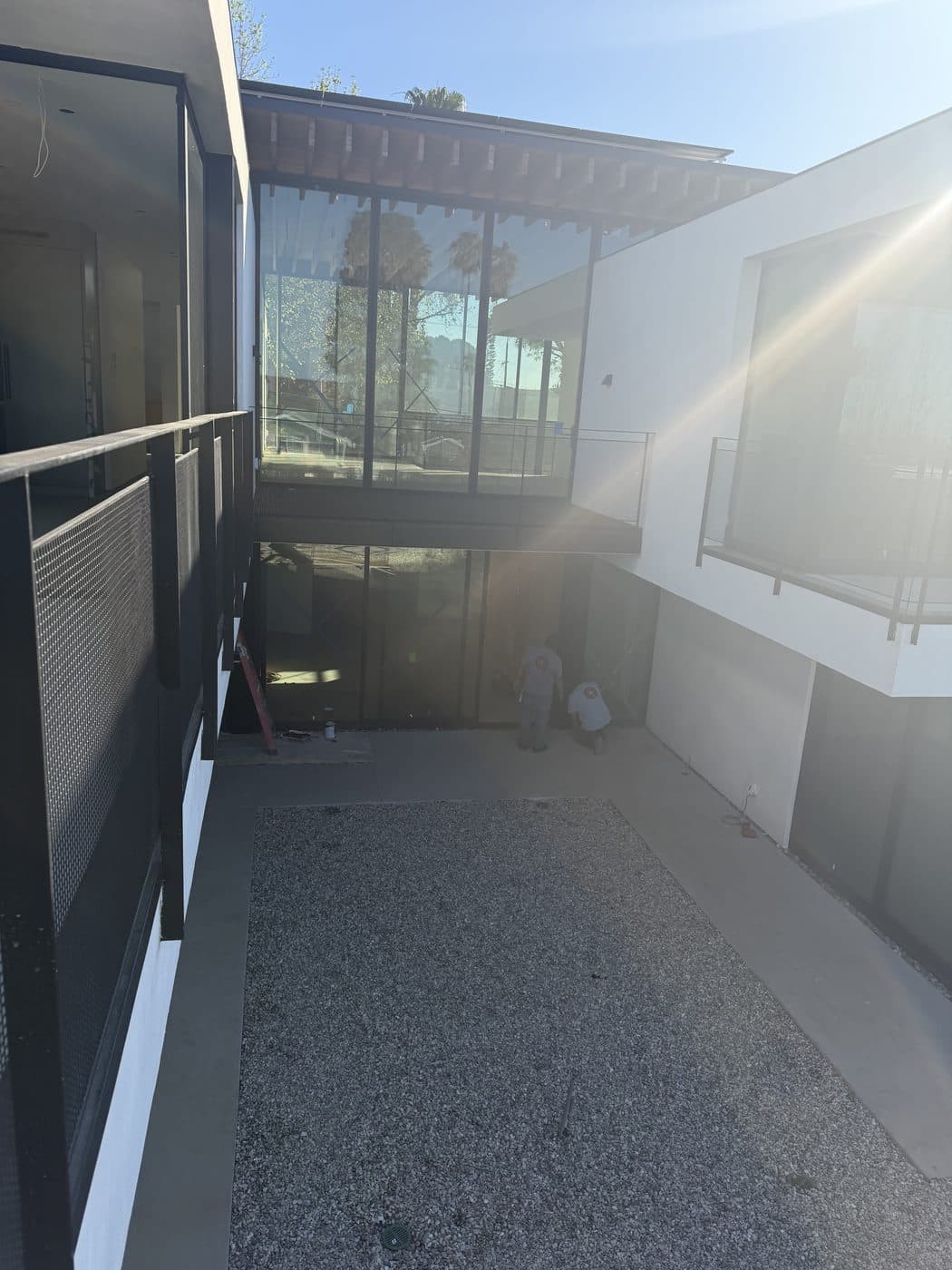 The Window Wizards crew cleaning a two-story glass wall in a modern Los Angeles courtyard