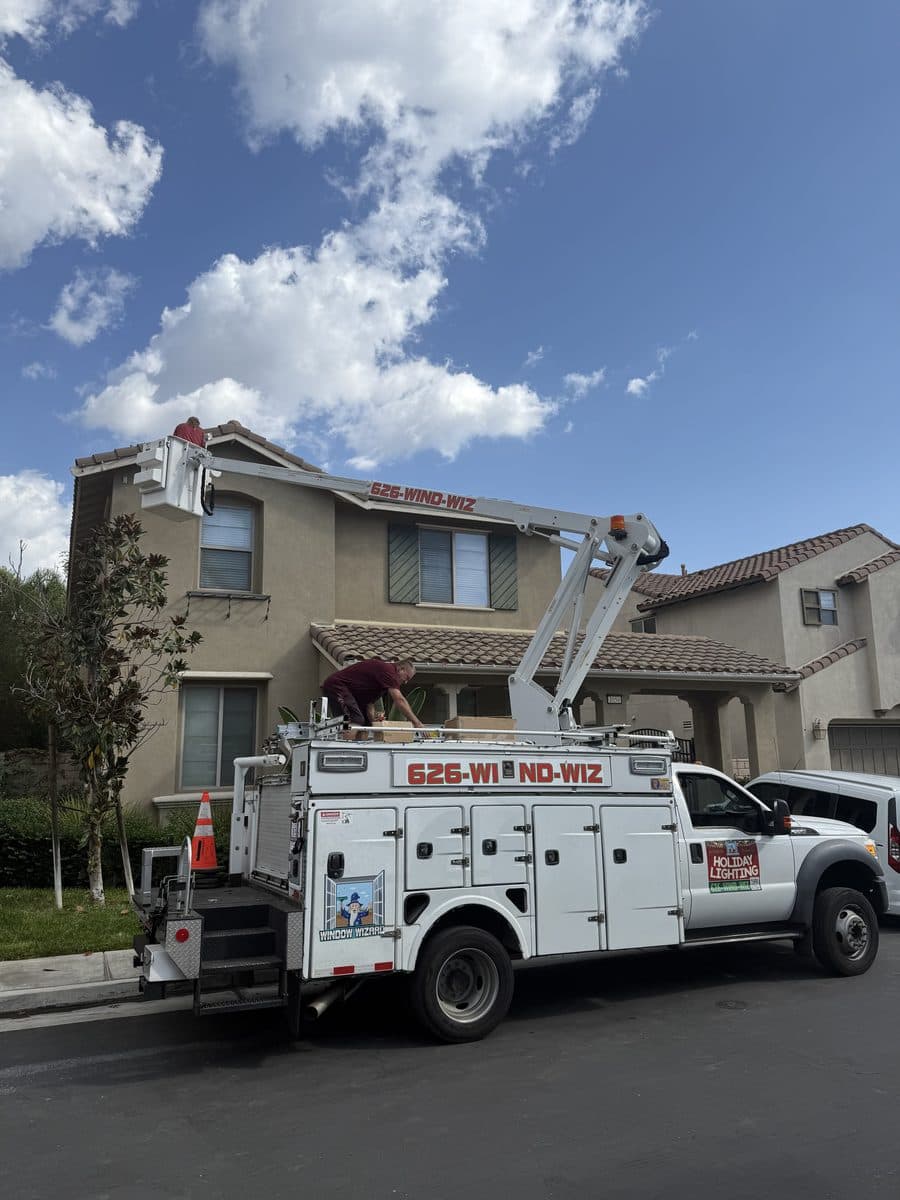 Window Wizards branded boom truck installing holiday lights on a two-story Los Angeles home